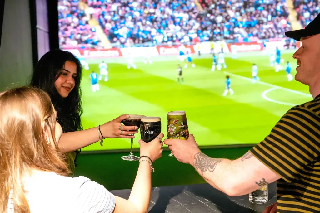 A group of friends having drinks and watching live sports on a 5 meter big screen